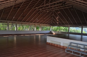 An indoor space with a high ceiling, large windows, and a wooden floor. - INDIMASI - Ayurveda & Healing Village (Nedumangad)