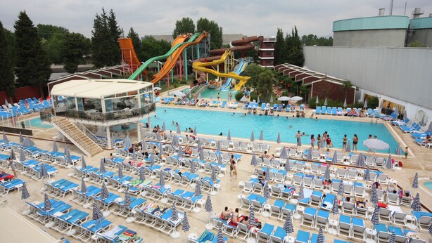 A water park with multiple slides and a large pool area with sun loungers and umbrellas. - Aqua Marin Spa&Wellness (Altinova)