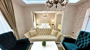 A hotel room with a large bed, two armchairs, a coffee table, and a chandelier. - Aqua Marin Spa&Wellness (Altinova)