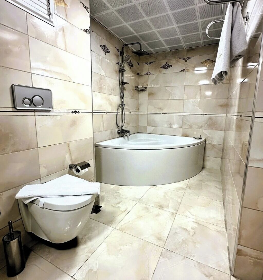 Un baño con inodoro, bañera y ducha.