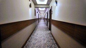 A long, narrow hotel corridor with patterned carpet, wooden paneling on the walls, and recessed lighting on the ceiling. - Aqua Marin Spa&Wellness (Altinova)