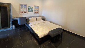A modern bedroom with a bed, bedside table, and a desk with a chair. There are two wall-mounted air conditioning units and a window with a view. - Hotel Riviera Ramatou Plage (Lomé)
