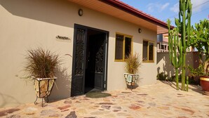 A building with a reception area, two potted plants, and a cactus. - Janjay Hotel (Accra)