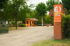 A garden river hotel with a brick entrance sign, a small building, and a gated driveway. - Garden River - Campsite (Altidona)