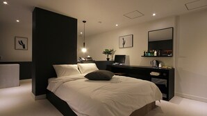 A modern bedroom with a large bed, bedside tables, a desk, and a mirror. - Busan Haeundae Hotel A (Busan)