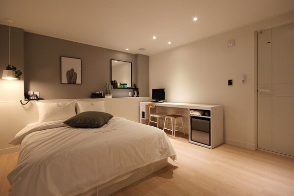 Une chambre à coucher moderne avec un lit, un bureau et une chaise.