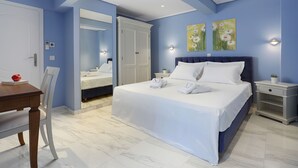 A bedroom with a bed, bedside tables, a nightstand, a chair, a table, and a mirror. - V1935 Luxurious Apartments (Athens)