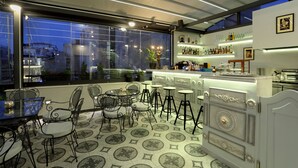 A modern bar area with a bar counter, stools, and a variety of bottles. - V1935 Luxurious Apartments (Athens)