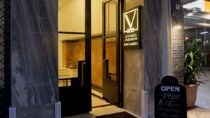 A building entrance with a sign reading "LUXURIOUS APARTMENTS" and "1935". - V1935 Luxurious Apartments (Athens)