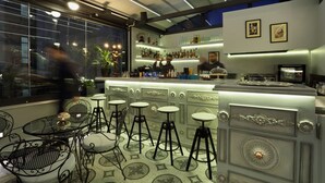 A bar area with a counter, stools, and a view of the street outside. - V1935 Luxurious Apartments (Athens)