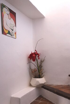 Relax in a stylish space with a vibrant planter and unique artwork.