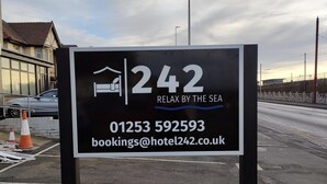 Naamplaatje voor Hotel 242 met een telefoonnummer en e-mailadres.