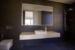 A modern bathroom with a large mirror, a rectangular sink, and a shower area. - Villa Amara Oliver Palm Resort (Marrakech)