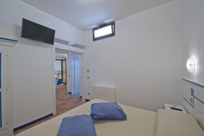 1 quarto, escrivaninha, ferros/tábuas de passar roupa, berço de viagem