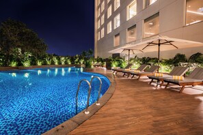 Alberca al aire libre, sombrillas en la alberca y camastros 