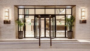 A hotel entrance with a revolving door, potted plants, and a checkered floor pattern. - Lemon Tree Premier Mumbai Intl. Airport (Mumbai)