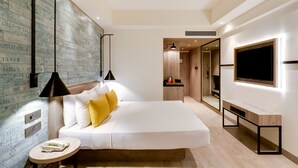 A modern hotel room with a large bed, a bedside table, a TV mounted on the wall, and a wooden accent wall with text. - Lemon Tree Premier Mumbai Intl. Airport (Mumbai)