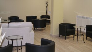Un espace de détente moderne, doté de canapés, de fauteuils et de tables rondes.