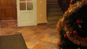 Un intérieur de maison avec un escalier, une porte et un sapin de Noël.