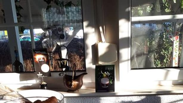 Een marmeren aanrecht met drie schalen eten, een decoratieve lamp en een raam met uitzicht op de omgeving.
