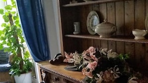 Een kamer met een houten kast, een plant in een pot en een witte kat.