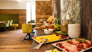 A breakfast buffet with various food items and a wooden wall in the background.