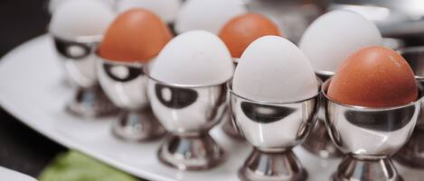 A plate with several eggs in egg cups.