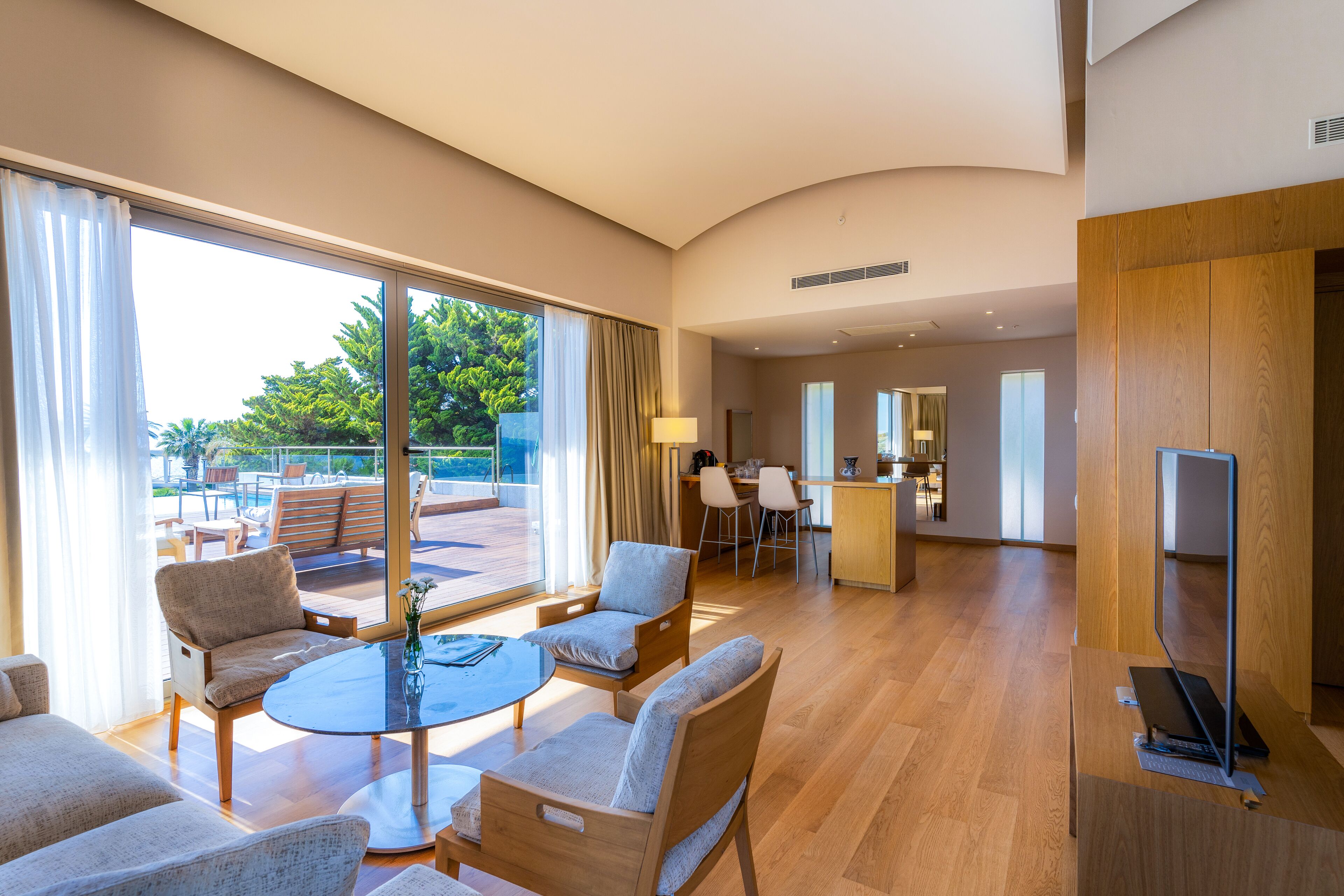 Una habitación amplia con un gran ventanal, un comedor y un televisor.