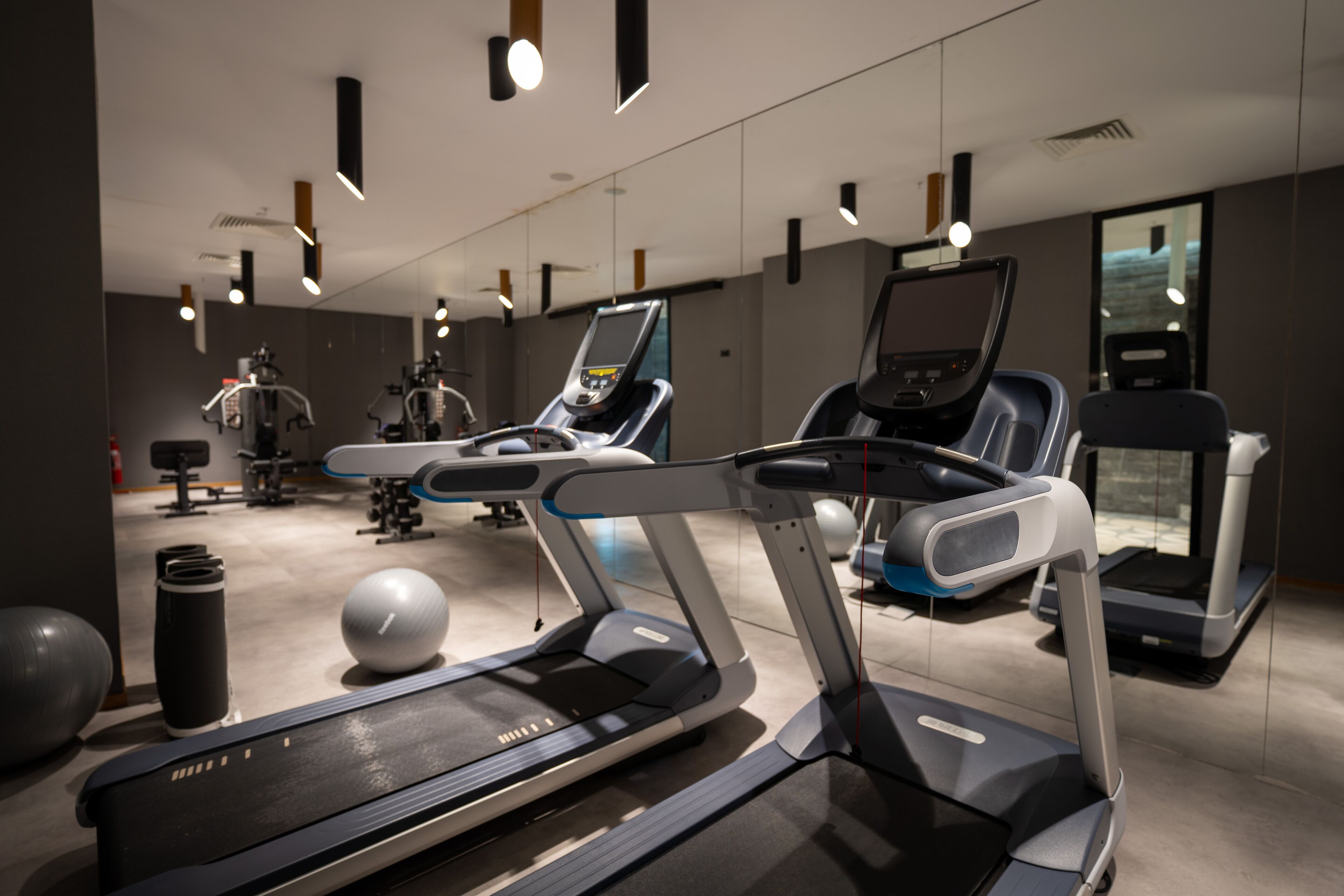Een moderne sportschool met loopbanden, fitnessballen en diverse fitnessapparaten.