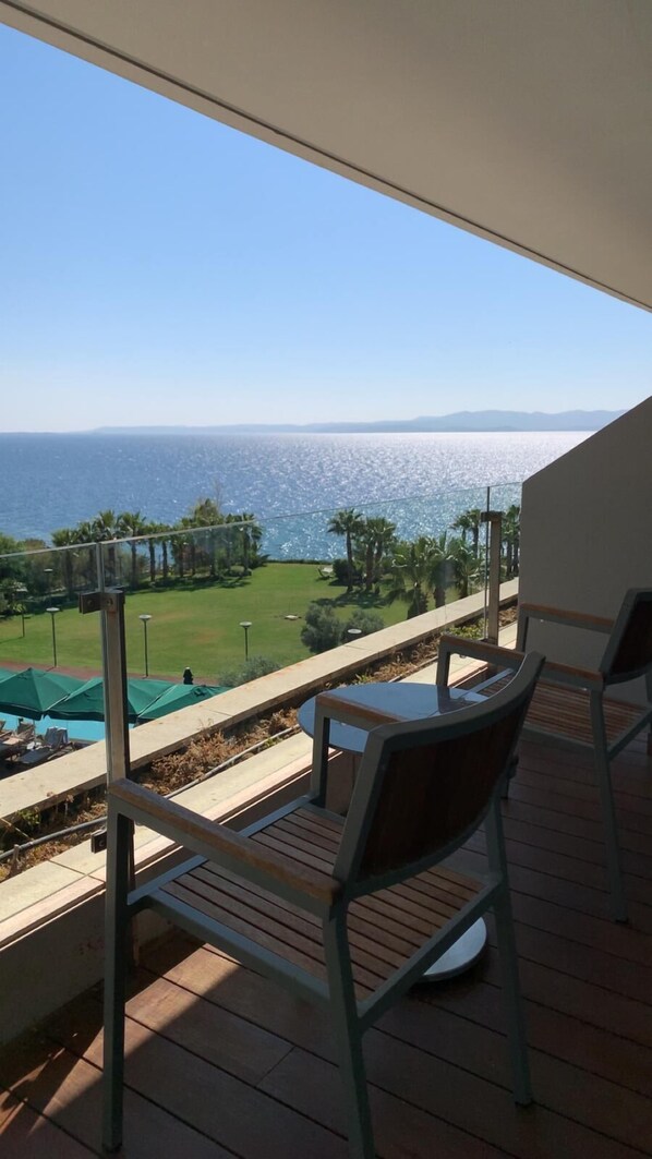Ein Balkon mit Blick auf das Meer, inklusive Tisch und Stühlen.