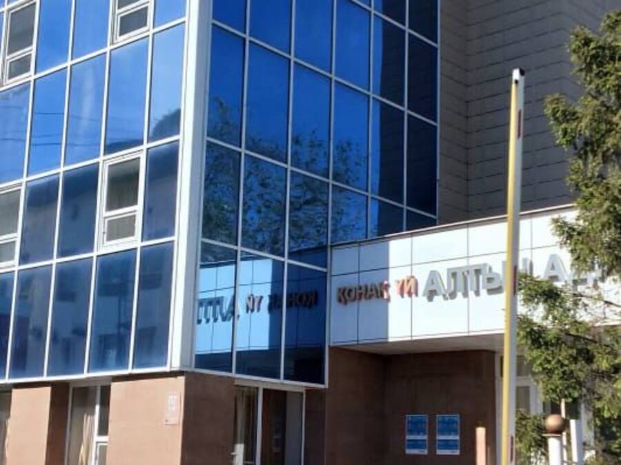 A modern building with a glass facade and a sign that reads 'KONTAKT'.