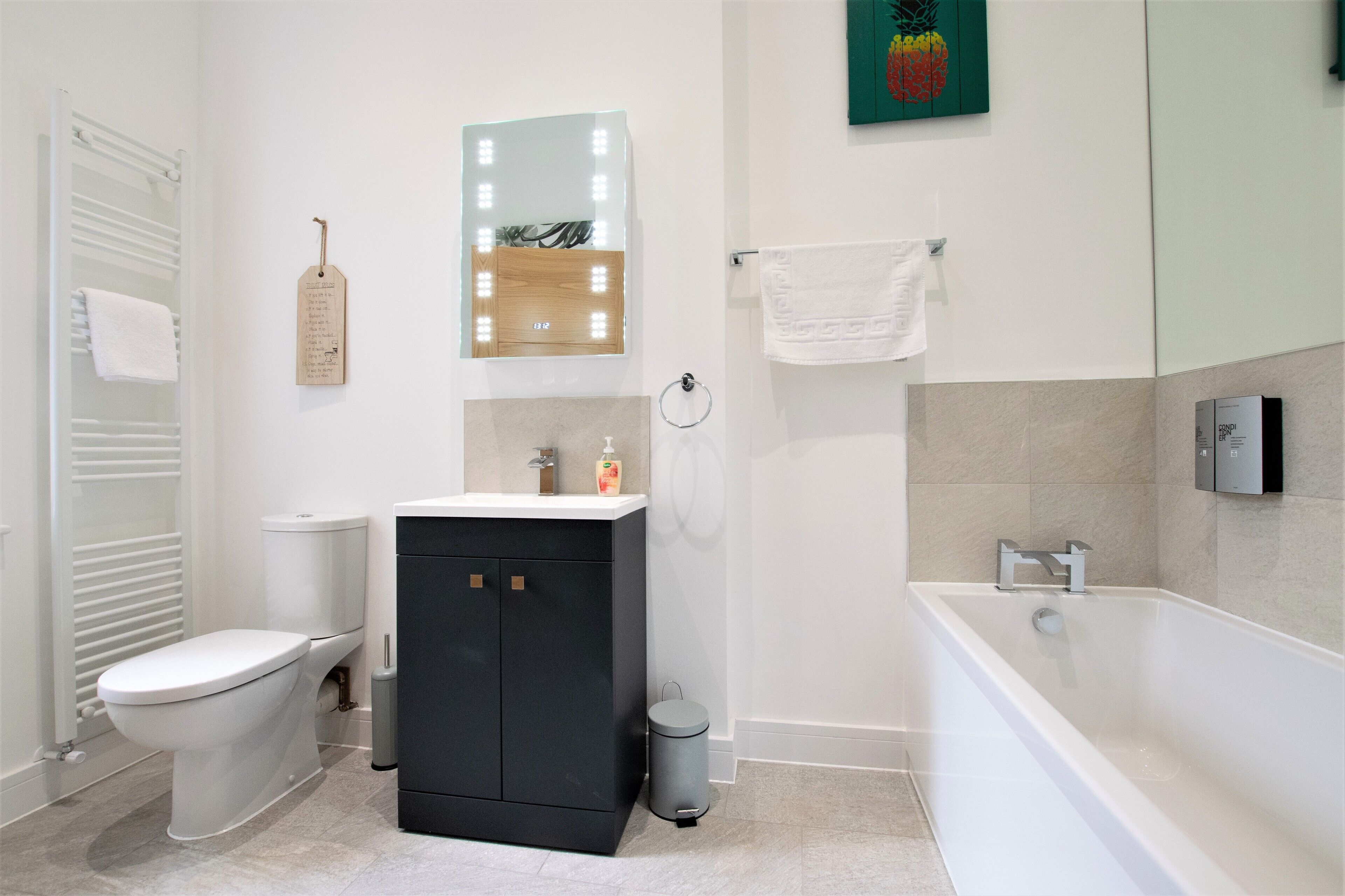 A modern bathroom with a toilet, sink, and bathtub.