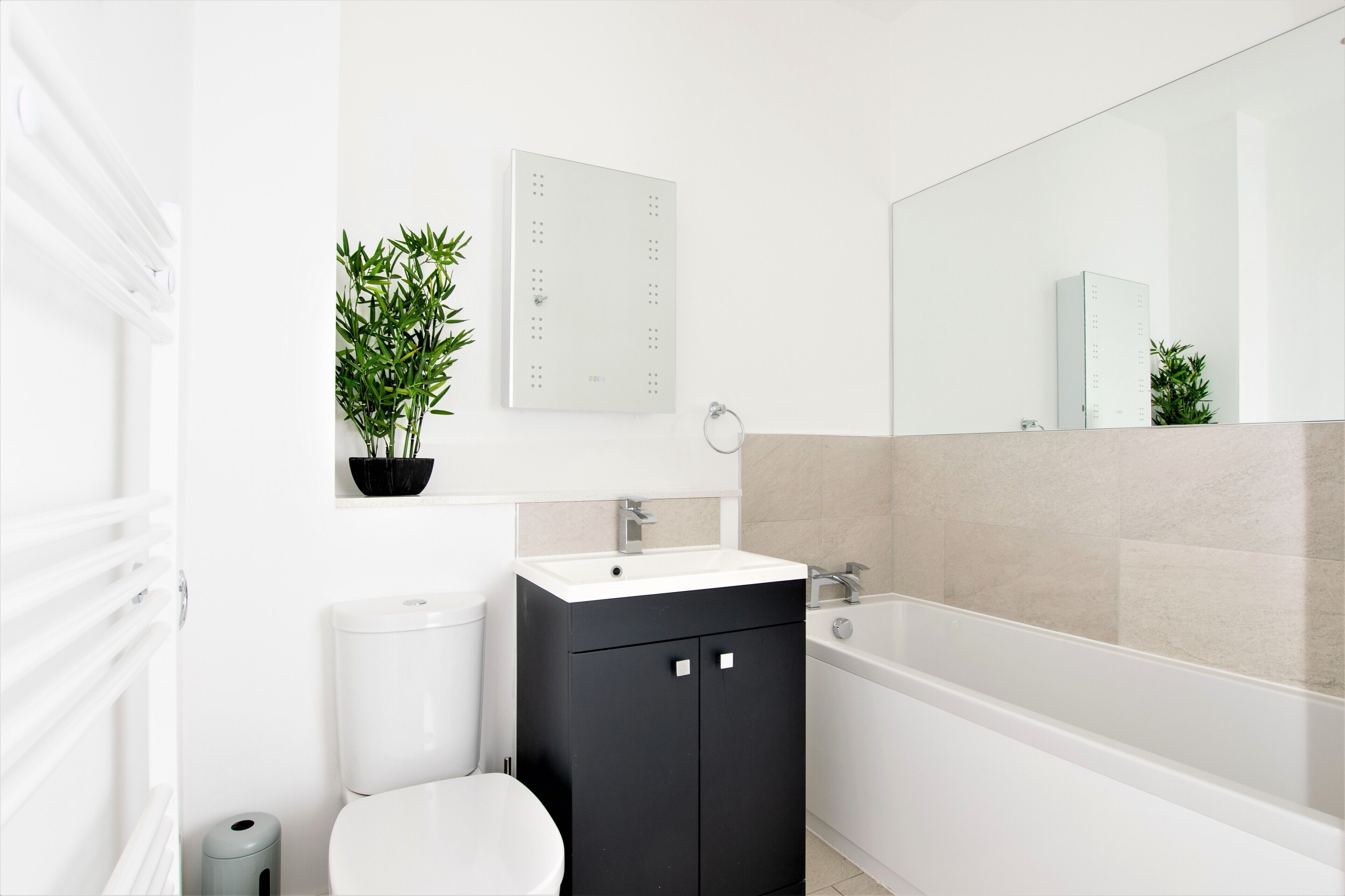 Un baño moderno con inodoro, lavamanos y bañera.