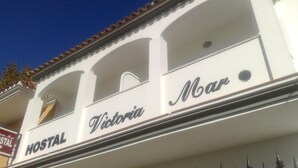 Un edifici amb el rètol "Victoria Mar Hostal" que indica que és un hostal.