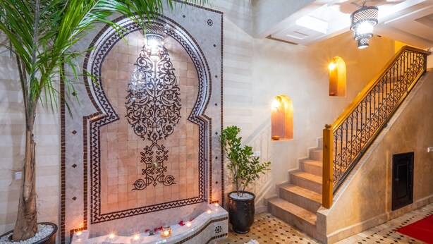 A staircase with a decorative wall and a potted plant. - Riad Elite (Marrakech)