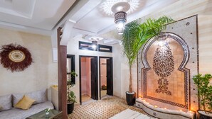 A modern interior with a sofa, a decorative wall, and a patterned floor. - Riad Elite (Marrakech)