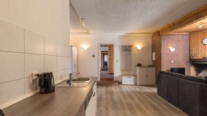 A modern kitchen with a wooden countertop, a built-in oven, and a brick wall. - Eifelnatur (Haus 2) by Interhome (Immerath)