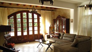 Un salón espacioso con un sofá grande, una mesa de centro y un aparador de madera.