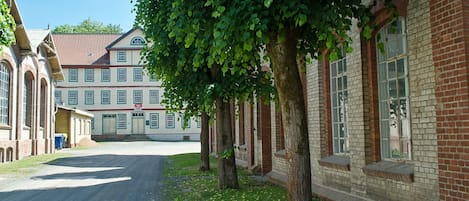 A building with a red brick facade, large windows, and a covered entrance.