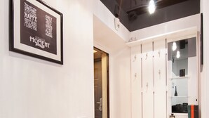 Ein modernes Interieur mit einem gerahmten Zitat an der Wand, ein begehbarer Kleiderschrank mit Platz zum Aufhängen und eine Sitzbank.