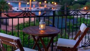 A wooden table with a white lantern on it, set on a balcony with metal railings. - Modern 5 * villa with pool, only 70m from the beach (Vantacici)