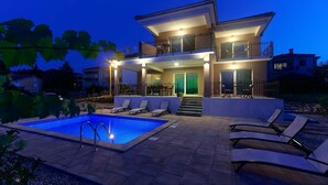 A modern two-story house with a swimming pool and outdoor seating. - Modern 5 * villa with pool, only 70m from the beach (Vantacici)