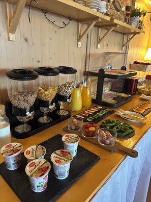 A buffet with various food items, including cereal, yogurt, and a selection of meats and vegetables. - Hotel Altes Sudhaus (Aschaffenburg)