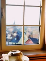 Ein Fenster mit Blick auf Gebäude und einen Kirchturm.
