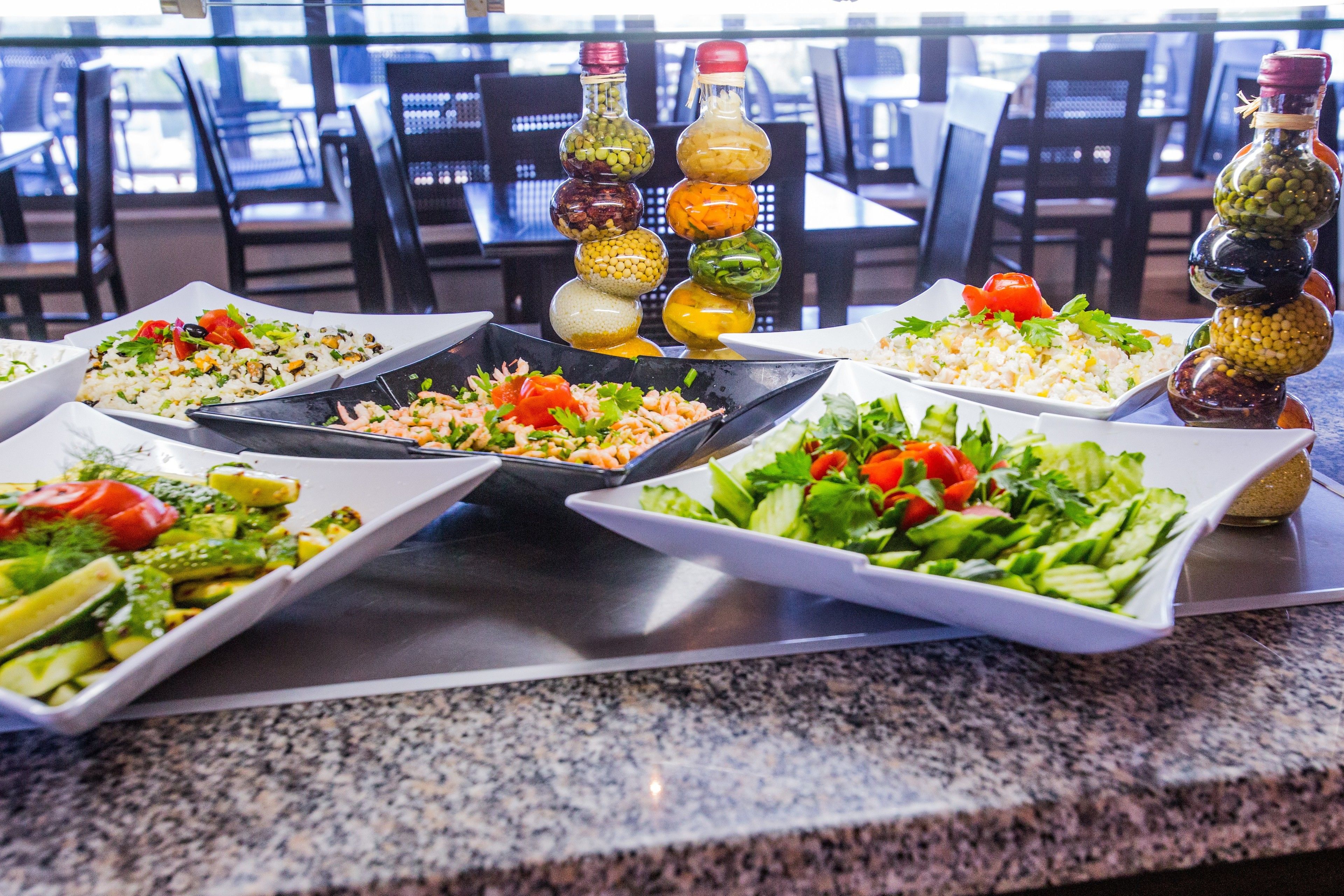 A buffet with various dishes and condiments.