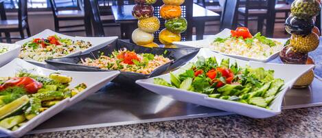 A buffet with various dishes and condiments.