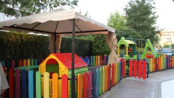 Children can play and explore in this vibrant play area with a house and climbing frame.