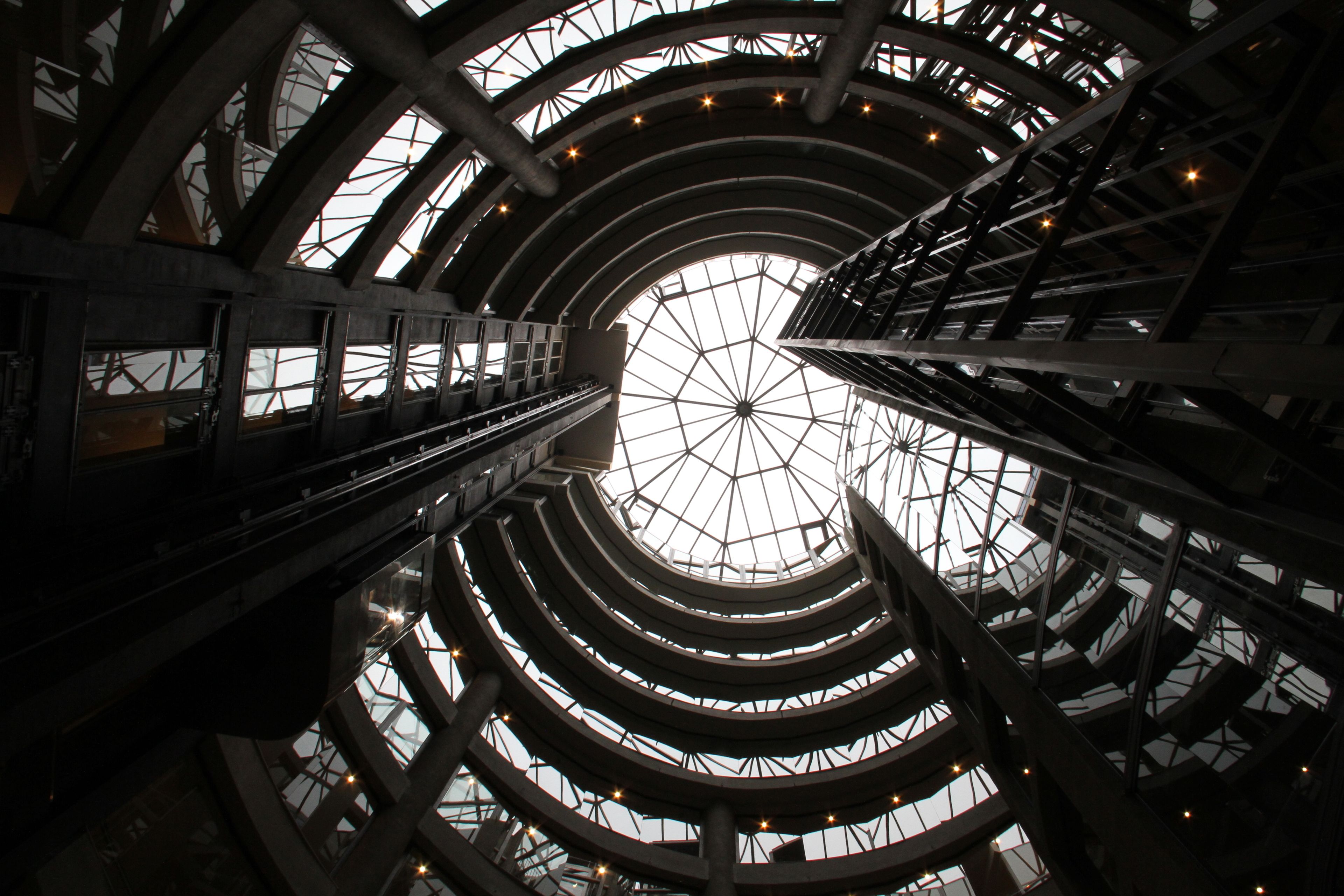 A multi-level atrium with a glass ceiling and steel framework.