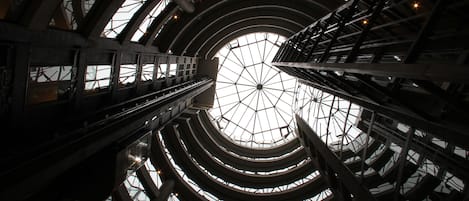 A multi-level atrium with a glass ceiling and steel framework.