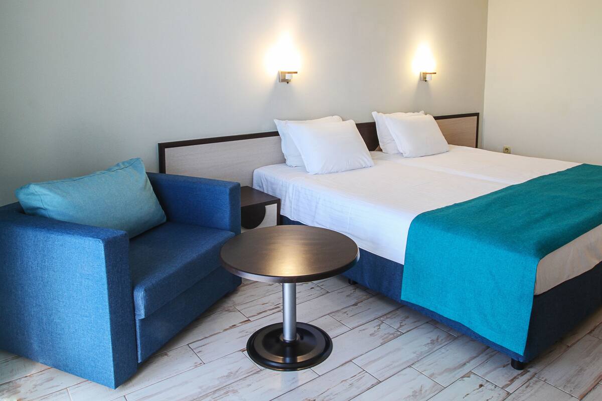 Minibar, escritorio, cortinas blackout y tabla de planchar con plancha 